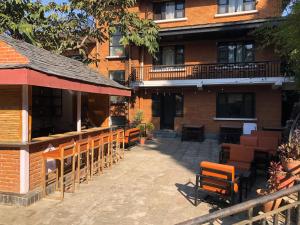 a row of wooden chairs and tables in front of a building at Himalayan Hideaway in Bākhri Kharka