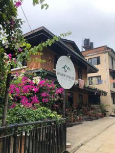a sign in front of a building with flowers at Himalayan Hideaway in Bākhri Kharka