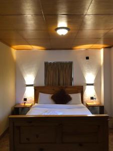 a bedroom with a large bed with two lights on it at Himalayan Hideaway in Bākhri Kharka