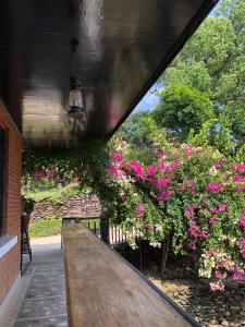 a wooden bench in front of some pink flowers at Himalayan Hideaway in Bākhri Kharka