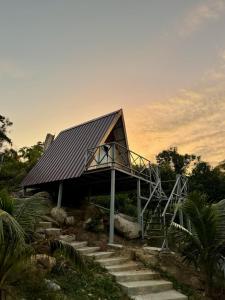 a house with a metal roof and stairs at Sea PoeTree in Koh Rong Sanloem