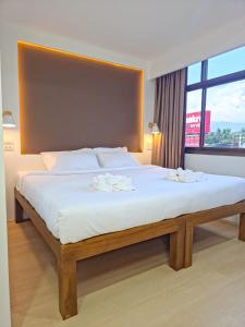 ein Schlafzimmer mit einem großen Bett und einem großen Fenster in der Unterkunft SANDB Hotel in Ko Phangan