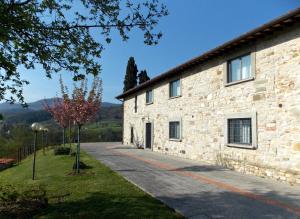 a stone house with a pathway next to a building at Villa Santa Maria a Bovino in Vicchio