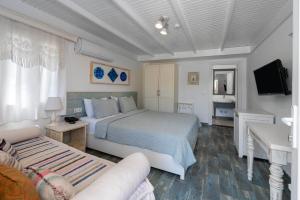 a bedroom with a bed and a tv and a couch at Kefi Beach & Suites in Ortakent