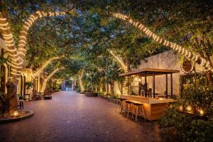a walkway with trees and a table and chairs at HELLO VILLA & SPA in Hue