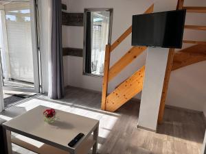 a living room with a table and a tv and a staircase at Villa Over Lake in Mielno