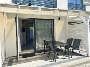 a black table and chairs on a patio at Villa Over Lake in Mielno +15 photos