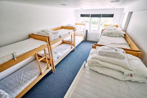 a room with three bunk beds and a window at Fyrtårn Tommerup Hostel in Tommerup