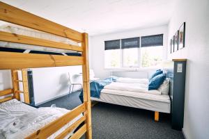 a bedroom with two bunk beds and a desk at Fyrtårn Tommerup Hostel in Tommerup