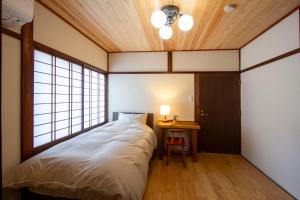 a bedroom with a large bed and a table at 女性専用お宿にこに in Izumo +10 photos