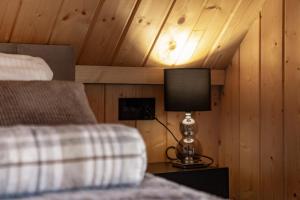 a bedroom with a bed and a lamp on a night stand at RzepiskaView in Rzepiska