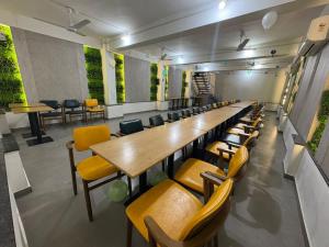 a conference room with long tables and yellow chairs at Hotel Govind Regency in Dhule