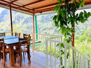 a dining room with a table and chairs on a balcony at Green Village in Ella