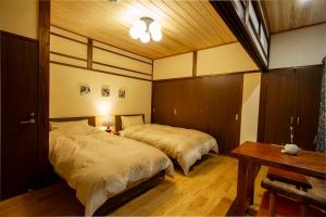 a bedroom with two beds and a table and a table sidx sidx sidx at 女性専用お宿にこに in Izumo