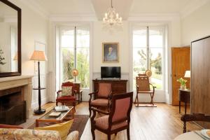 a living room with a couch and a fireplace at Le jardin de L'Hippodrome in Chantilly