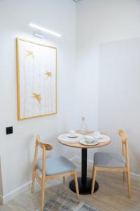 a dining room table with two chairs and a painting at Sea Star Boutique Hotel in Almaty