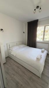 a white bed in a room with a window at Luxury Lion Crib in Bacău