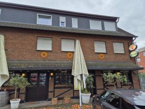 a building with an umbrella in front of it at Restaurant Zur Linde in Bergheim