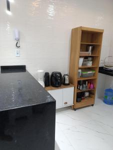 a kitchen with a counter and a book shelf at SSP Ubajara in Ubajara