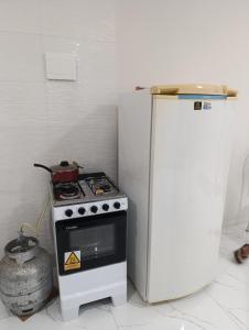 a kitchen with a stove and a refrigerator at SSP Ubajara in Ubajara