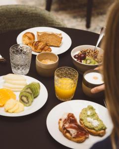 a table with plates of breakfast food on it at Palacio Pinello in Seville +40 photos