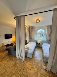 a bedroom with two beds and a living room at Bavaria Home - Terrasse, Küche, Parken in Geisenfeld