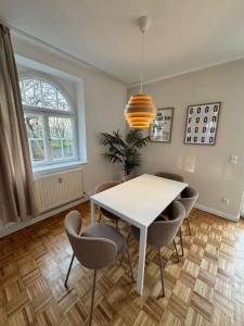 a dining room with a white table and chairs at Bavaria Home - Terrasse, Küche, Parken in Geisenfeld