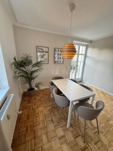 a dining room with a white table and chairs at Bavaria Home - Terrasse, Küche, Parken in Geisenfeld +12 photos