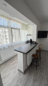a kitchen with a counter and two stools in a room at Luxury Lion Crib in Bacău