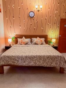 a bedroom with a bed with a clock on the wall at GoArize by Rootsvilla Vagator in Anjuna