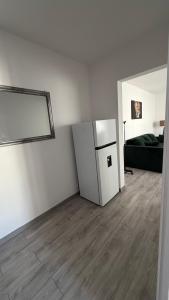 a white room with a refrigerator and a couch at Luxury Lion Crib in Bacău +2 photos