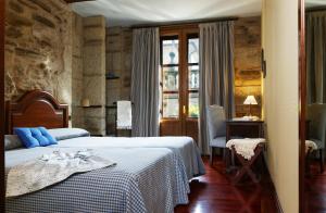 Un dormitorio con una cama con almohadas azules. en Hotel Rua Villar, en Santiago de Compostela