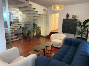 a living room with a blue couch and white chairs at Hotel Boutique Palacio del Moral in Ronda