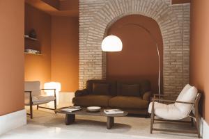 a living room with a couch and chairs at Palacio Pinello in Seville