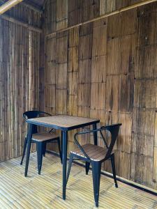 a table and two chairs next to a wooden wall at Baan Bamboo Koh Tao in Ko Tao