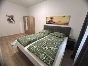 a bedroom with a bed with a green comforter at R03 Central Residence in Sopron +19 photos