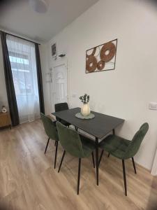 a dining room with a black table and green chairs at R03 Central Residence in Sopron