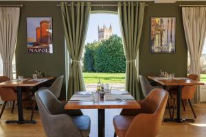 a restaurant with tables and chairs in front of a window at Northgate House in Buckfastleigh