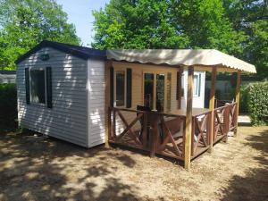 a small shed with a porch and an awning at Camping Les Pins de Sel in Saint-Augustin