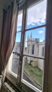 an open window with a view of a church at La Bonne Etoile, près Giverny in Vernon