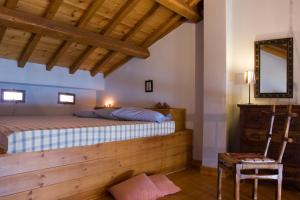 ein Schlafzimmer mit einem Bett, einem Spiegel und einem Stuhl in der Unterkunft Stolios Skopelos - Panoramic Seaview Gems in Skopelos