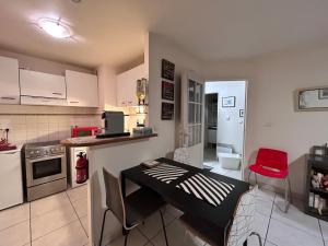 a kitchen with a table and a red chair in it at 31 Bd De Launay in Nantes +10 photos