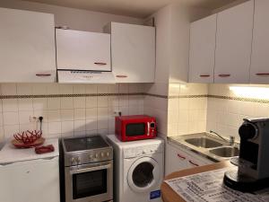 a kitchen with a microwave and a washing machine at 31 Bd De Launay in Nantes