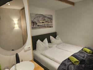 a small room with a bed and a mirror at No1 - Flo's modern Rooms & Breakfast in Wagrain