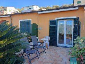 a patio with chairs and a table in front of a building at Casa Rita in Civezza