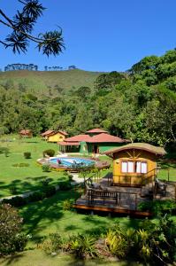 a house with a swimming pool and a building at Pousada Villa Acauã in Visconde De Maua