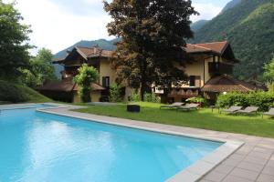 a villa with a swimming pool in front of a house at Casa Ornella in Ledro