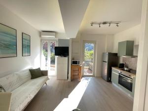 a living room with a white couch and a kitchen at Casa Leone sea&terrace in Bogliasco