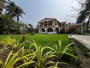a house with a green lawn in front of it at Prangan - The Villa in Chākdaha
