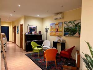 a living room with colorful chairs and a piano at Juliette Rooms in Iesi